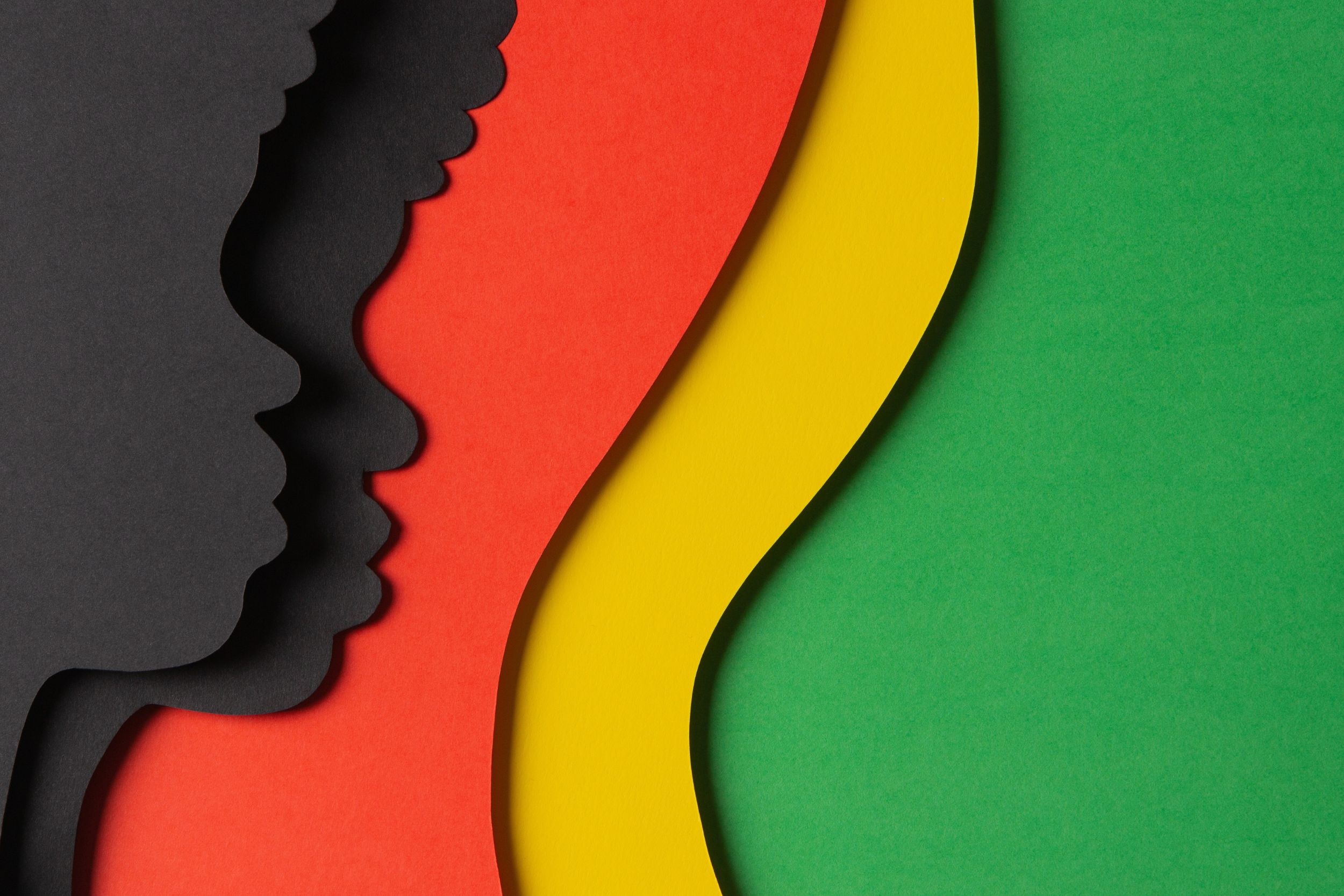 Papercut-style silhouettes of two faces in profile against layered red, yellow and green, marking Black History Month